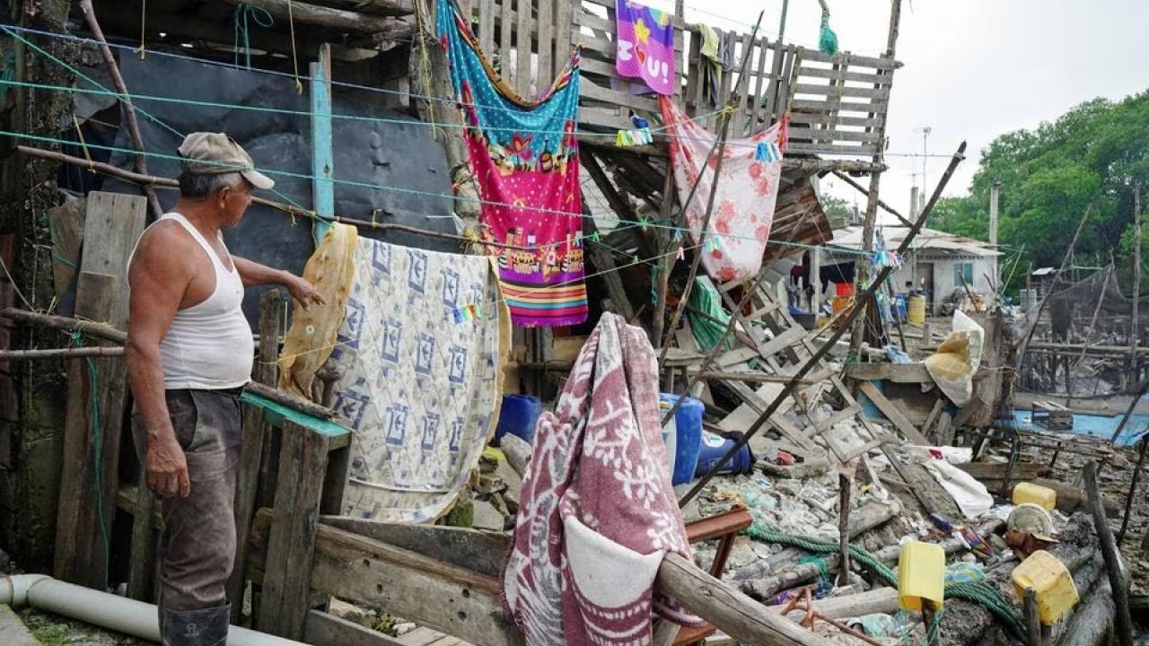 A man points at a damaged house following an earthquake in Isla Puna, Ecuador.