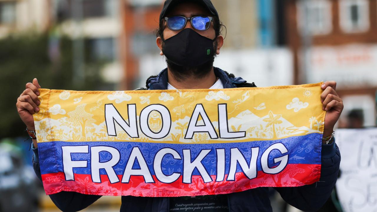 Un hombre sujeta una bandera colombiana con la frase "No al fracking" durante una protesta contra los proyectos piloto de fracking, en Bogotá, Colombia, 22 de abril, 2022. REUTERS/Luisa González